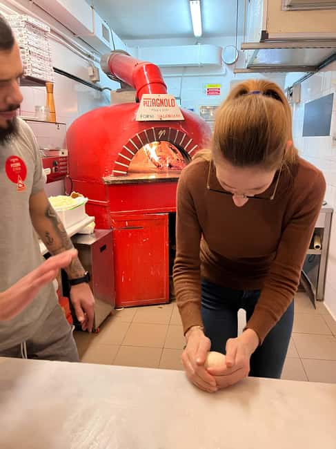 Florence: Private Pizza Making Class with Wine Tasting - Tending a pizza in the wood-fired oven